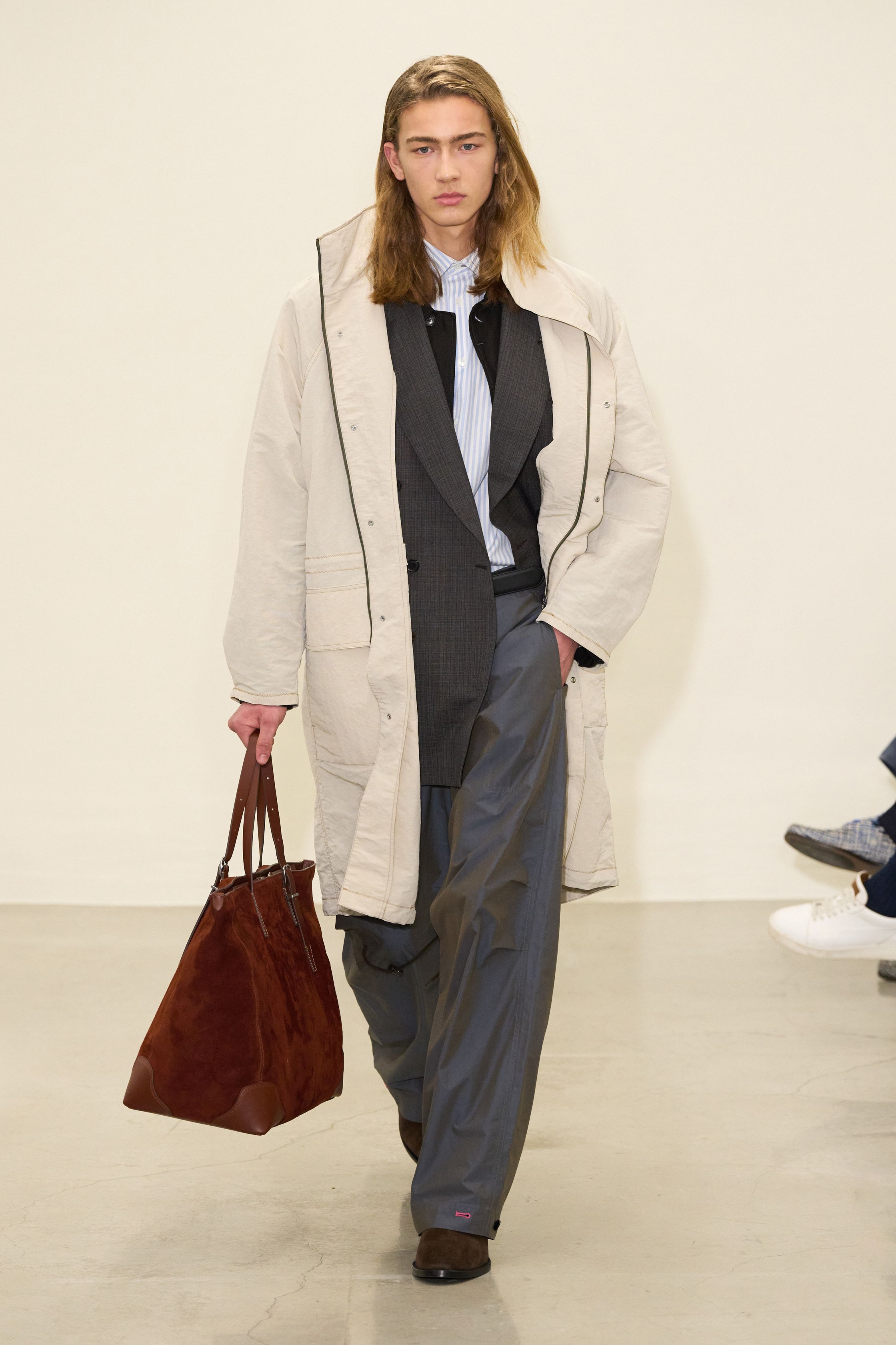 Paul Smith 2026秋冬回归品牌最具识别度的“英式日常诗意”。系列以传统剪裁为骨架，却通过色彩点缀、围巾叠搭与比例微调，赋予男装更松弛的情绪温度。西装不再严肃，风衣与大衣在肩线与长度上释放空间，搭配针织与衬衫形成轻度混搭。整体传递的是一种文化型男性的穿衣态度——不追逐潮流，却始终保持幽默感与个人风格-顽石频道趋势研究